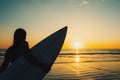 Silhouette of beautiful sexy surfer female with surfboard on the sandy beach at sunset. Royalty Free Stock Photo