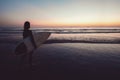 Silhouette of beautiful sexy surfer female with surfboard on the sandy beach at sunset. Royalty Free Stock Photo