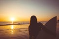 Silhouette of beautiful sexy surfer female with surfboard on the sandy beach at sunset Royalty Free Stock Photo