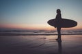 Silhouette of beautiful sexy surfer female with surfboard on the sandy beach at sunset. Royalty Free Stock Photo