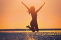 Silhouette of a beautiful, slim girl who jumps on a background of a sunset. Royalty Free Stock Photo