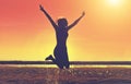 Silhouette of a beautiful, slim girl who jumps on background of a sunset on the beach. Royalty Free Stock Photo