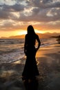 Silhouette of a beautiful woman on the background of the sea at sunset .