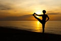 Silhouette of beautiful woman standing one leg in yoga pose on the beach with sunrise in background Royalty Free Stock Photo