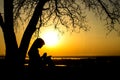 Silhouette of woman praying to God in the nature witth the Bible at sunset, the concept of religion and spirituality Royalty Free Stock Photo