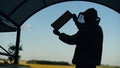 Silhouette of Beekeeper man checking wooden frame before harvesting honey in apiary