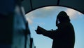 Silhouette of Beekeeper man cleaning wooden frame before harvesting honey in apiary