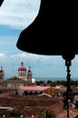 Silhouette of a bell over chuch and house rooftops Royalty Free Stock Photo