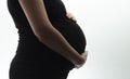 Silhouette of belly of pregnant woman hugging baby with hands on white isolated background Royalty Free Stock Photo