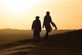 Silhouette of Berber and camel at bloody red sunset, Merzouga in Morocco, Sahara Desert, North Africa