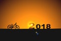 Silhouette bicycle in 2018 text on sunset with lens flare Royalty Free Stock Photo