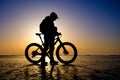 Silhouette of bicyclist on the ice of frozen lake