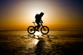 Silhouette of bicyclist riding on the clear ice