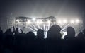 Silhouette of big audience crowd of happy people standing at concert grounds cheering clapping use smart phones raising hands up