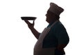Silhouette of a big-bellied happy chef carrying a dish in pan on his hand on a white isolated background, good-natured man`s