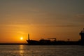 Silhouette of a big container ship at sunrise and exit from a Royalty Free Stock Photo