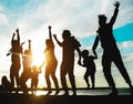 Silhouette of big family having fun on the beach at sunset - Father, mother, children and uncles enjoying time together - Focus on