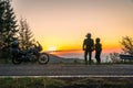 Silhouette of biker couple girl man and adventure motorcycle on the road with sunset light. Top of mountains, tourism motorbike, Royalty Free Stock Photo