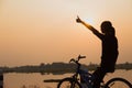 Silhouette biker-girl at the sunset on the meadow Royalty Free Stock Photo