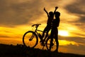 Silhouette biker lovely family sitting and talking at sunset over the ocean. Royalty Free Stock Photo