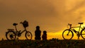 Silhouette biker lovely family sitting and talking at sunset over the ocean