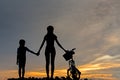 Silhouette biker lovely family at sunset over the ocean. Mom and daughter bicycling at the beach. Royalty Free Stock Photo