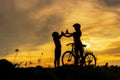 Silhouette biker lovely family at sunset over the ocean.  Mom and daughter bicycling chill and relax at the beach. Royalty Free Stock Photo