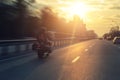 Silhouette of biker riding black chopper motorcycle on city street highway road and sunset bright dramatic sky on Royalty Free Stock Photo