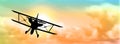 Silhouette of biplane with clouds
