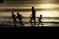 Silhouette of black childrens playing soccer at the beach at sunset Royalty Free Stock Photo