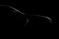 Silhouette of black sports car with headlights on black background Royalty Free Stock Photo