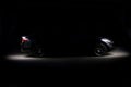 Silhouette of black sports car with headlights on black background Royalty Free Stock Photo