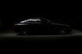 Silhouette of black sports car with headlights on black background Royalty Free Stock Photo