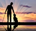 Silhouette of a blind disabled man stroking his dog guide