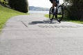 Silhouette of blurred in motion cyclists on shared pathway with sign in surface \