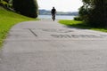 Silhouette of blurred in motion cyclists on shared pathway with sign in surface \