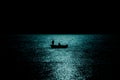 Silhouette of boat fishing in the sea in moonlight reflection reverse light Royalty Free Stock Photo