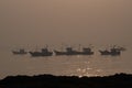Silhouette Boats floating on sea water during sunrise at sea shore with rocks