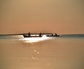 Silhouette of boats on the spot where the setting sun light falls