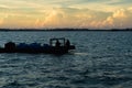 Silhouette of boats and unidentified man working early morning during sunrise. Royalty Free Stock Photo