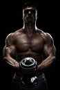 Silhouette of a bodybuilder pumping up muscles with dumbbell
