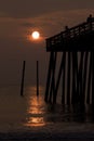 Silhouette of a boy fishing from a pier at sunrise Royalty Free Stock Photo