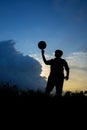Silhouette of boy with football during sky sunset background Royalty Free Stock Photo