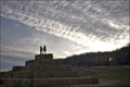 The silhouette of a boy and a girl on top of the bale of hay group in a pyramid wall pattern in agriculture farm at sunset Royalty Free Stock Photo