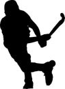 Silhouette of boy hockey player hitting ball