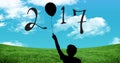 Silhouette of boy holding balloon forming 2017 new year sign