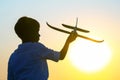Silhouette of a boy lets a model plane fly into the sky against the backdrop of the setting sun. Children`s dream of a future Royalty Free Stock Photo