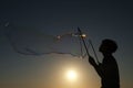 Silhouette boy playing with a bubble wand on the beach Royalty Free Stock Photo