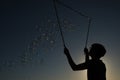 Silhouette boy playing with a bubble wand on the beach Royalty Free Stock Photo