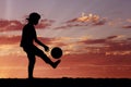 Silhouette of a boy playing football or soccer at Royalty Free Stock Photo